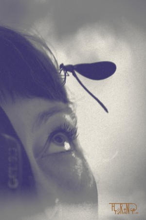 visage féminin avec une libellule sur le front